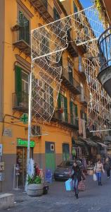 una mujer caminando por una calle frente a un edificio en B&B Donna Anna, en Nápoles