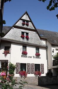 a large white building with flowers in the windows at Haus zur Traube in Klotten