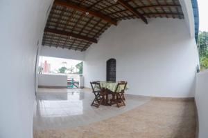 a dining room with a glass table and chairs at Recanto Jubarte (Massaguaçu Caraguatatuba - SP) in Caraguatatuba