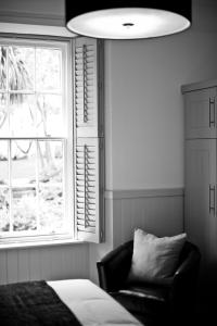 a bedroom with a bed and a chair and a window at 27 The Terrace in St Ives
