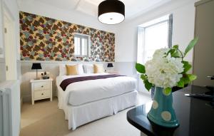 a bedroom with a bed and a vase of flowers on a table at 27 The Terrace in St Ives