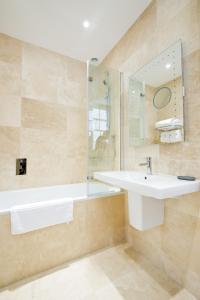 a bathroom with a sink and a tub and a mirror at 27 The Terrace in St Ives