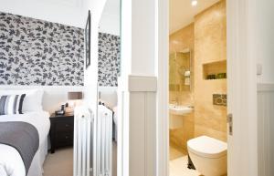 a bedroom with a bed and a toilet and a bathroom at 27 The Terrace in St Ives