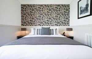 a bedroom with a white bed and a floral wallpaper at 27 The Terrace in St Ives
