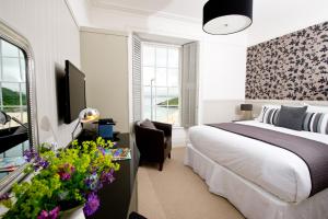 a bedroom with a bed and a desk with a television at 27 The Terrace in St Ives