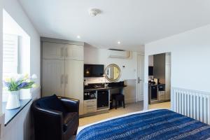 a bedroom with a bed and a chair and a mirror at 27 The Terrace in St Ives