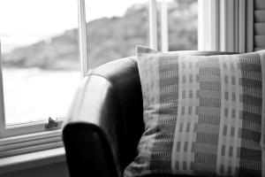 a couch with a plaid pillow in front of a window at 27 The Terrace in St Ives