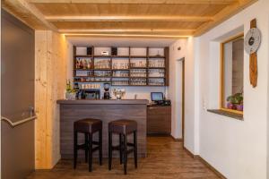 eine Bar im Flur eines Hauses mit zwei Hockern in der Unterkunft Gasthof Falkenstein in Naturns