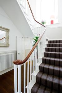 a staircase in a house with white walls and wooden floors at 27 The Terrace in St Ives