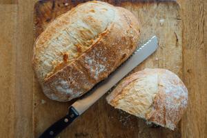a loaf of bread and a knife on a cutting board at 27 The Terrace in St Ives