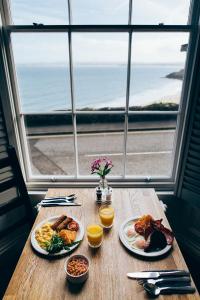 a table with two plates of breakfast food and a window at 27 The Terrace in St Ives
