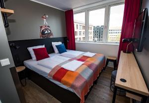 a bedroom with a bed with a colorful blanket on it at Generator Copenhagen in Copenhagen