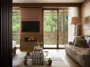 a living room with a couch and a fireplace at Lefay Resort & SPA Dolomiti in Pinzolo