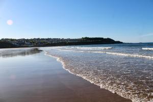 a beach with waves coming in from the ocean at Bungalow33 Benllech in Benllech