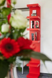 uma estante de livros vermelha ao lado de uma flor vermelha em Gästehaus am Landgut em Schönwalde