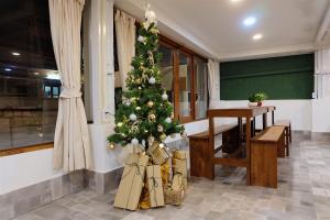 a christmas tree in a room with a table at Barn Laos Hostel in Vientiane