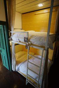 two bunk beds with a ladder in a room at Barn Laos Hostel in Vientiane