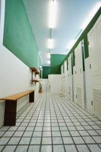 a hallway with lockers and a bench in a building at Barn Laos Hostel in Vientiane