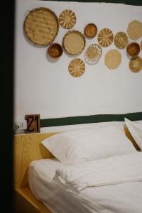 a bedroom with plates on the wall and a bed at Barn Laos Hostel in Vientiane