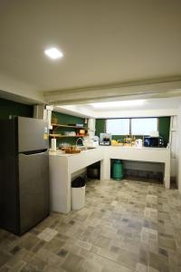 a large kitchen with a refrigerator and a counter at Barn Laos Hostel in Vientiane