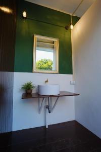 a bathroom with a sink and a window at Barn Laos Hostel in Vientiane