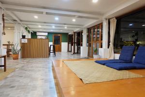 a living room with blue pillows on the floor at Barn Laos Hostel in Vientiane