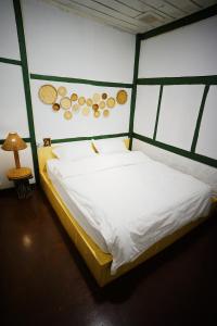 a bedroom with a large bed with white sheets at Barn Laos Hostel in Vientiane