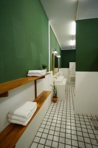 a bathroom with two sinks and a green wall at Barn Laos Hostel in Vientiane