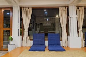 two blue chairs sitting in front of a window at Barn Laos Hostel in Vientiane