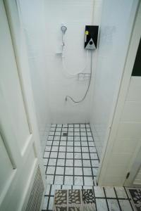 a bathroom with a shower and a tiled floor at Barn Laos Hostel in Vientiane