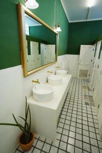 a bathroom with two sinks and a mirror at Barn Laos Hostel in Vientiane
