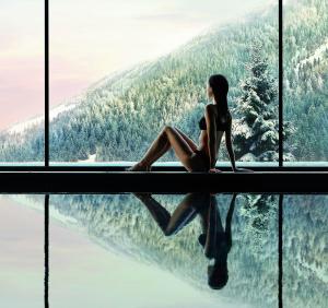 
a woman is sitting on a surfboard in the water at Lefay Resort & SPA Dolomiti in Pinzolo

