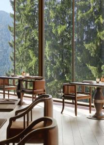 
a dining room with chairs, tables, and benches at Lefay Resort & SPA Dolomiti in Pinzolo
