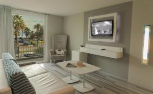 a living room with a couch and a table and a window at Hôtel Josse in Antibes