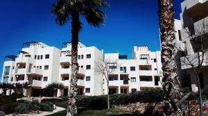 ein weißes Gebäude mit einer Palme davor in der Unterkunft gelijkvloers appartement Corvera Golf & Country Club in Corvera