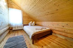 a room with a bed in a wooden cabin at Rāznas Pērle in Šlakoli