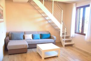 a living room with a couch and a staircase at Sogno Azzurro - ArgonautiVacanze in Porto Azzurro