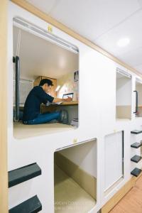 un homme assis à un bureau dans une pièce dans l'établissement Techgarden Workstay Dorm - Coworking Space, à Hanoï