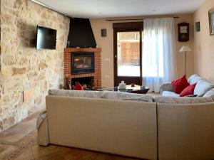 sala de estar con sofá y chimenea en Casa del Tío Marcelo, en Pedraza-Segovia