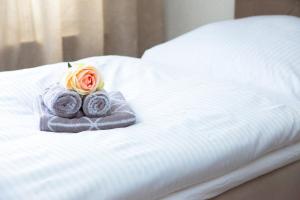 uma rosa sentada em cima de uma cama em T&K Apartments near Messe Fair Trade Düsseldorf und Airport 2B em Duisburg