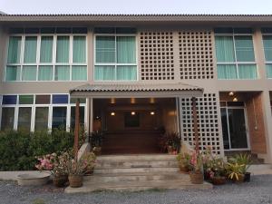 Mon-Dee minihotel في نان: منزل به درج يؤدي للباب الأمامي