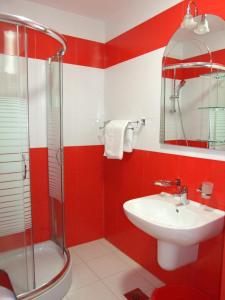 Un baño rojo y blanco con lavabo y ducha. en Beachfront Apartments Oaza 2, en Petrovac na Moru