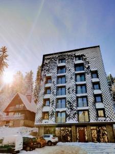 a tall building with snow on the side of it at Apartment A1 Lux Alpin in Jahorina