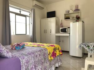 Habitación con cama y cocina con nevera. en Pousada Mera, en Florianópolis