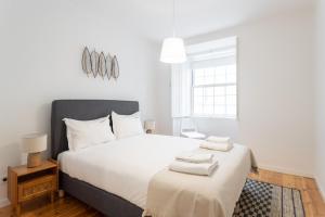 una camera con un letto bianco e una finestra di FLH Baixa Deluxe Flat a Lisbona