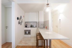 a kitchen with white cabinets and a white counter top at FLH Chiado Central Flat in Lisbon