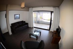 Ushuaia Flat I في أوشوايا: غرفة معيشة مع أريكة وطاولة زجاجية