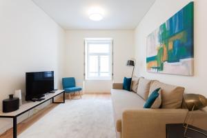 a living room with a couch and a tv at FLH Chiado Central Flat in Lisbon
