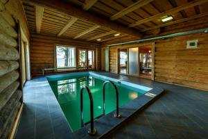 an indoor swimming pool in a wooden house at Rāznas Pērle in Šlakoli