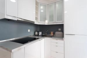 里斯本的住宿－FLH Mouraria Charming Flat II，白色的厨房配有白色橱柜和水槽